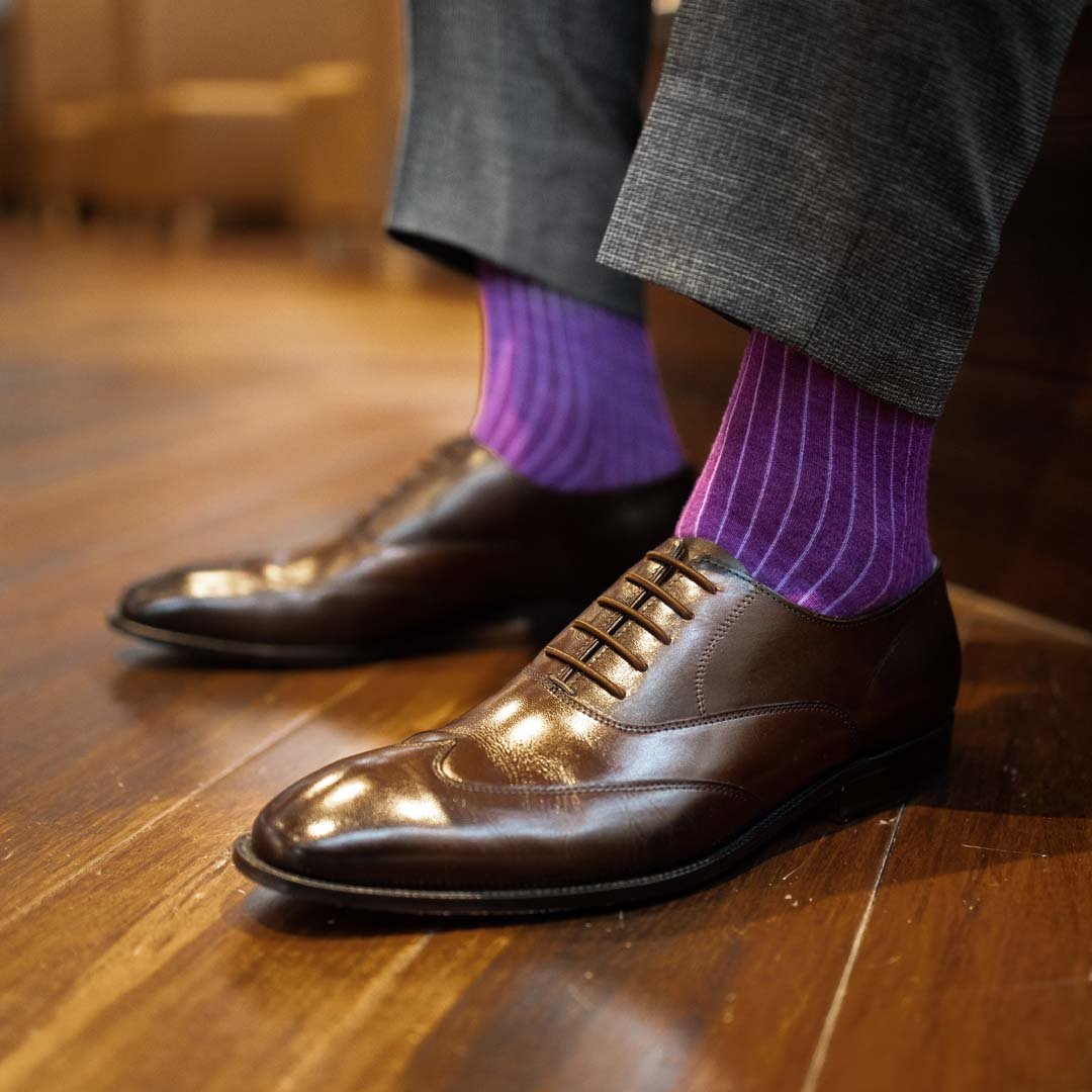 Man wearing plum, solid, violet ribbed men's dress socks with brown shoes.