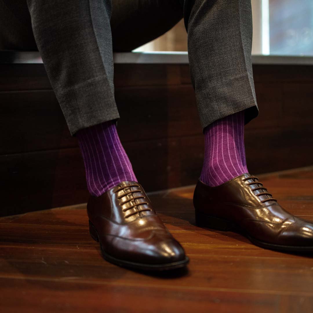 Man wearing plum, solid, violet ribbed men's dress socks with brown shoes.