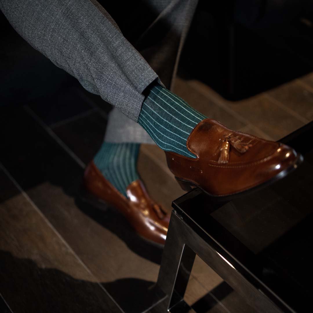 Man wearing hunter green, solid, Emerald ribbed men's dress socks with brown shoes.