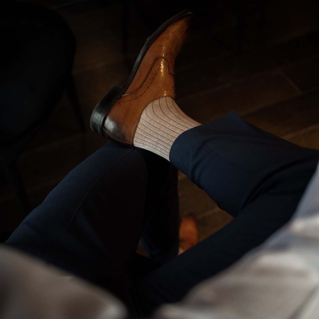 Man wearing oatmeal, solid, mocha ribbed men's dress socks.