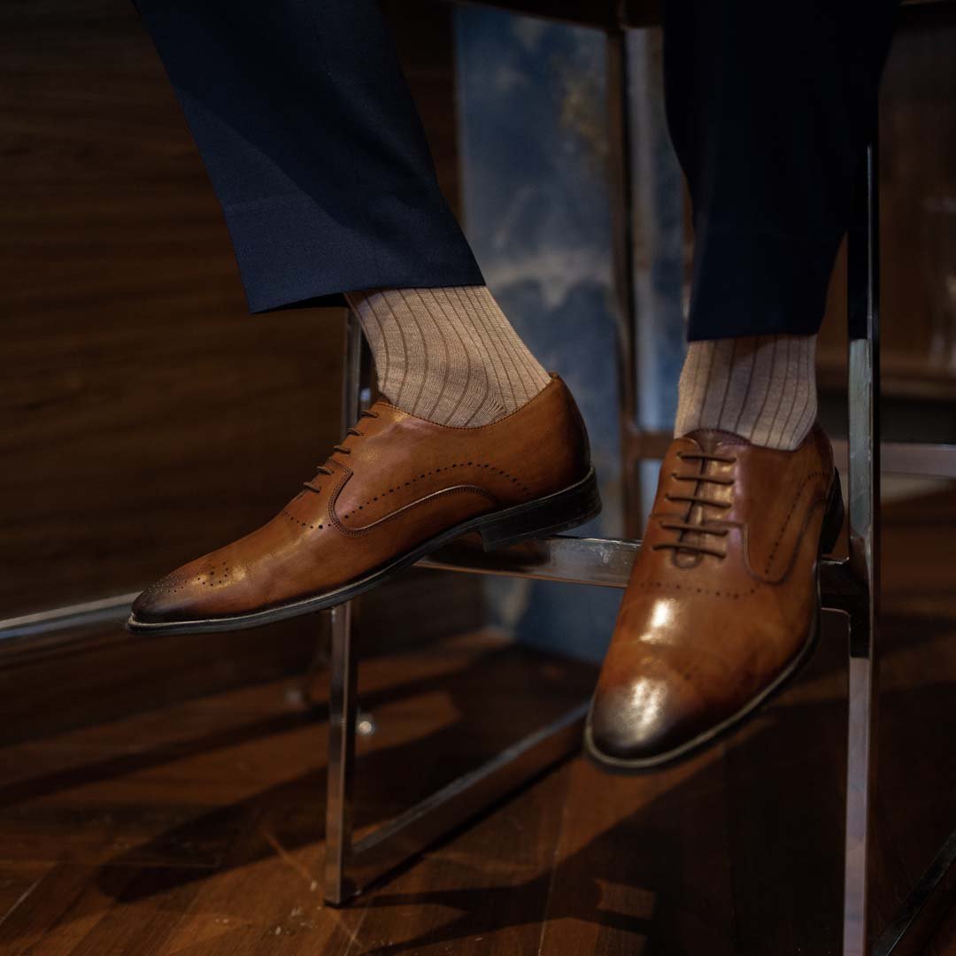 Man wearing oatmeal, solid, mocha ribbed men's dress socks.