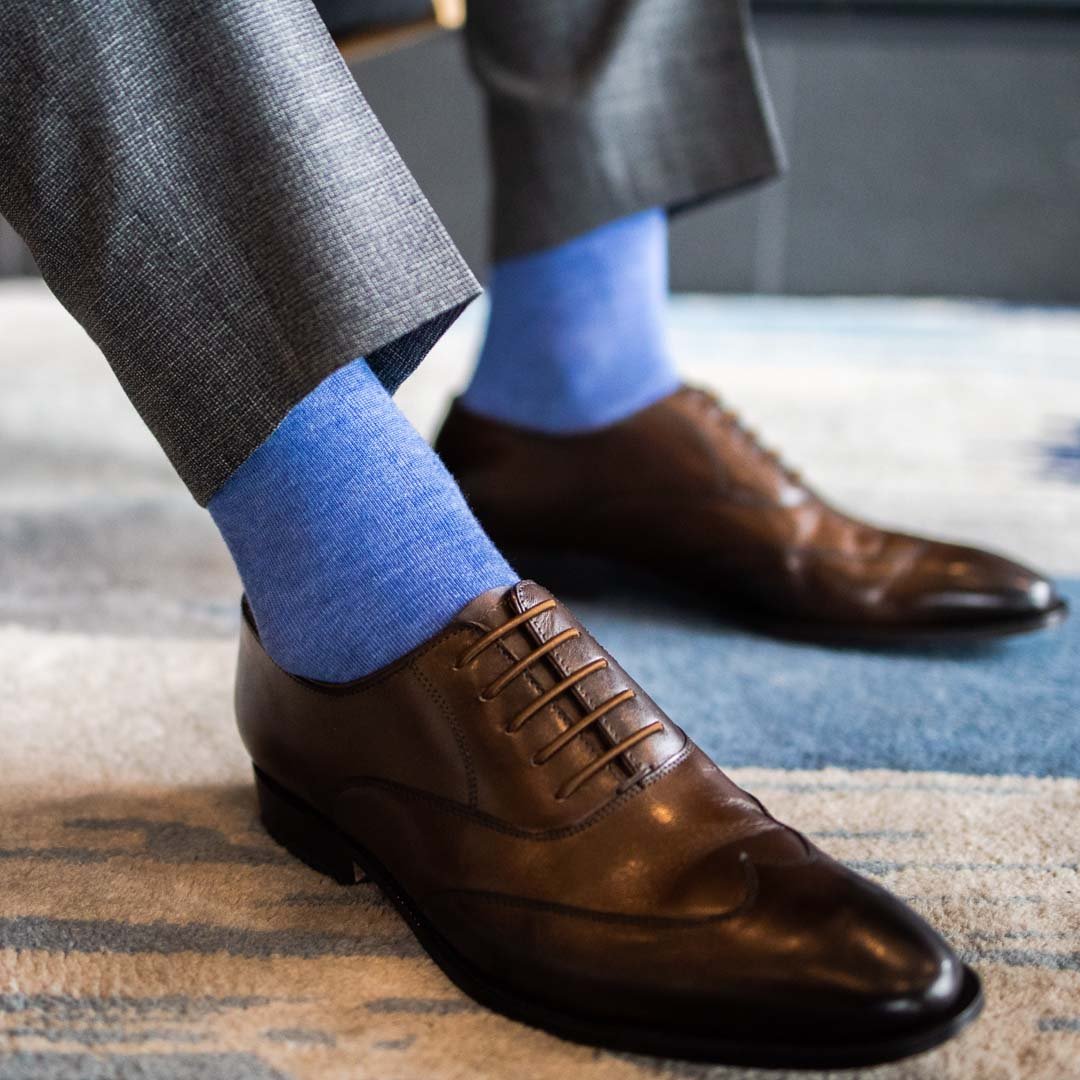 Man wearing steel blue men's dress socks and brown shoes.