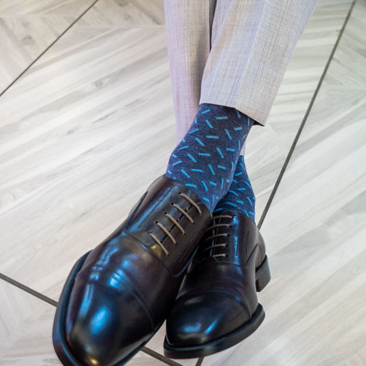 A dark blue men's dress sock with a light blue sprinkle pattern