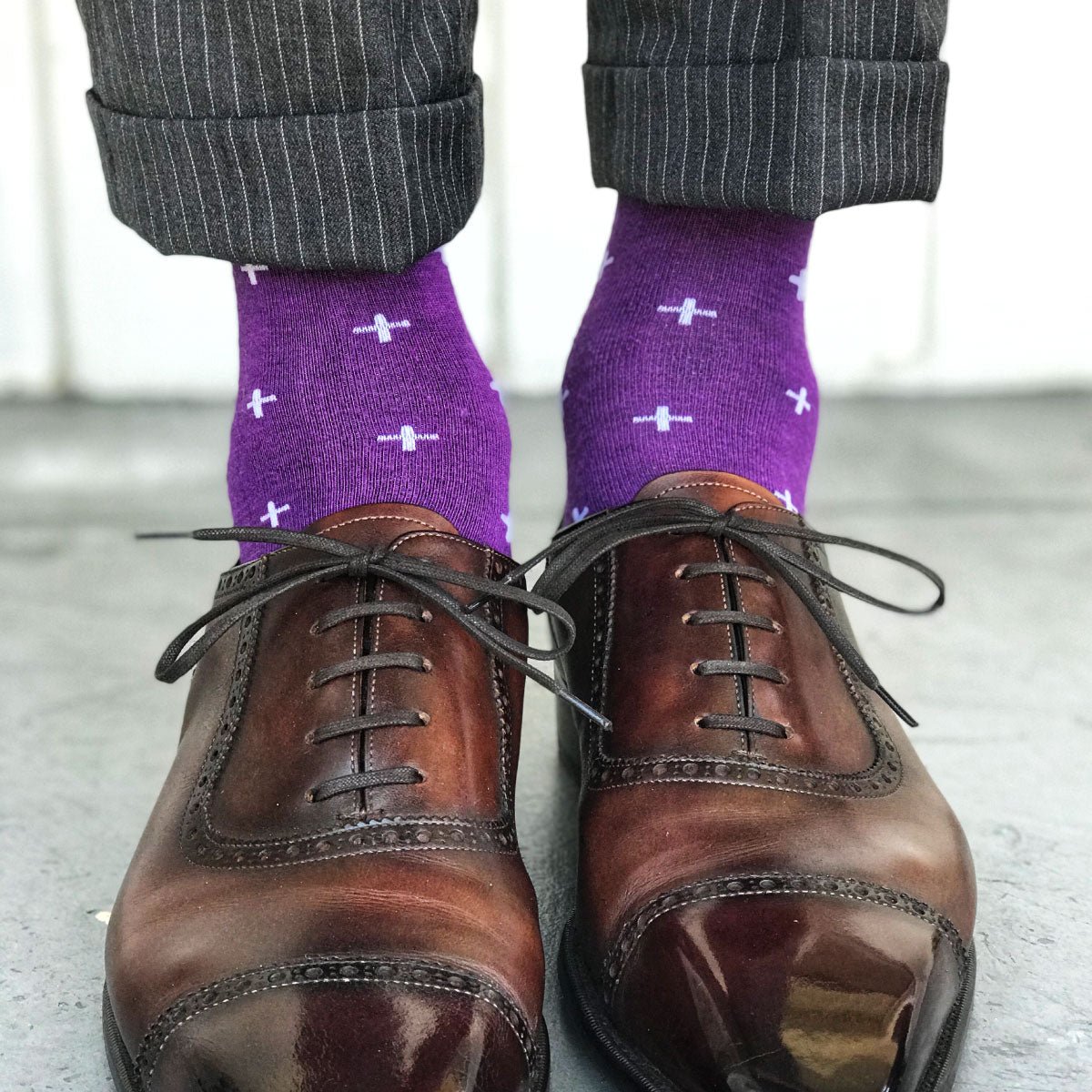 Guy wearing purple socks with grey slacks and brown shoes
