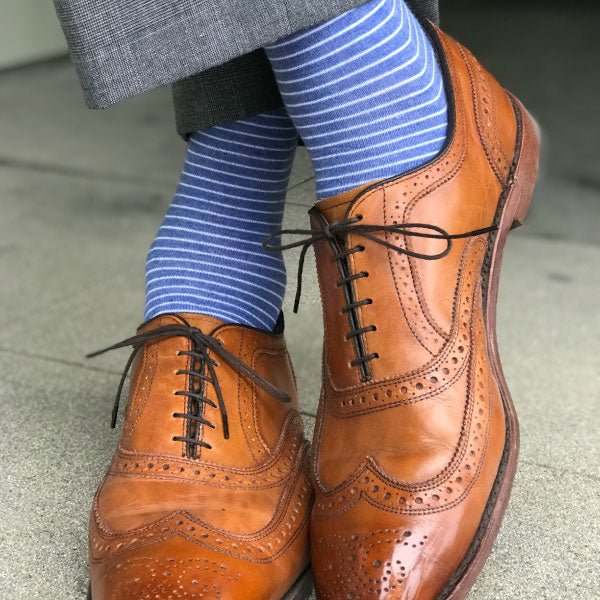 Man wearing blue striped socks and brown shoes