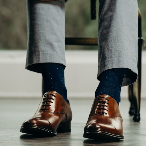 Man wearing blue socks with grey pants