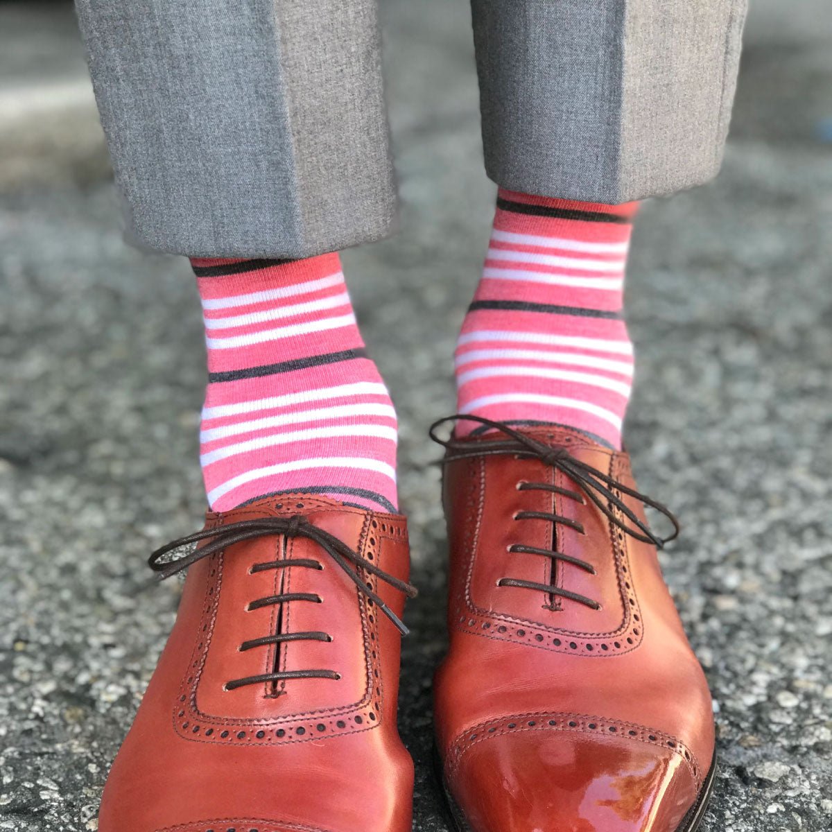 Guy wearing coral striped socks and grey pants