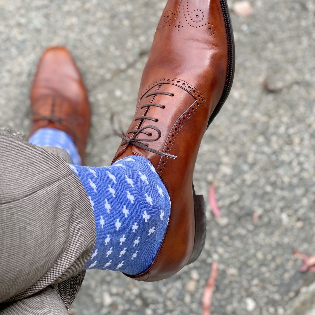 Man wearing heathered blue socks with white hatches and dress shoes