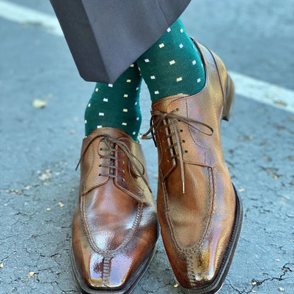 Man wearing green socks with white micro-squares and dress shoes