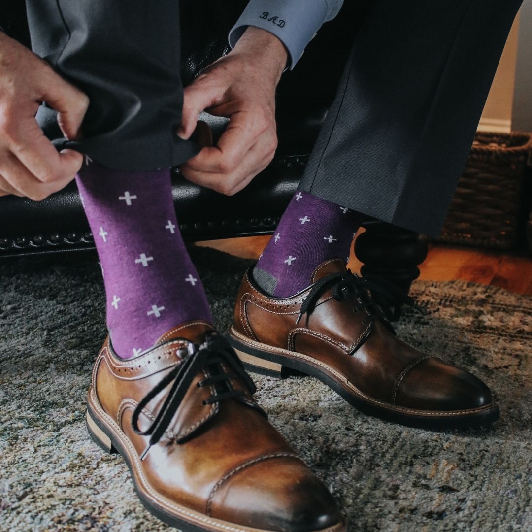 Man wearing purple dress socks with white hatches and brown dress shoes