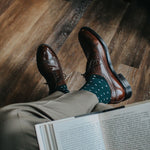 Man wearing green socks with white micro-squares and dress shoes
