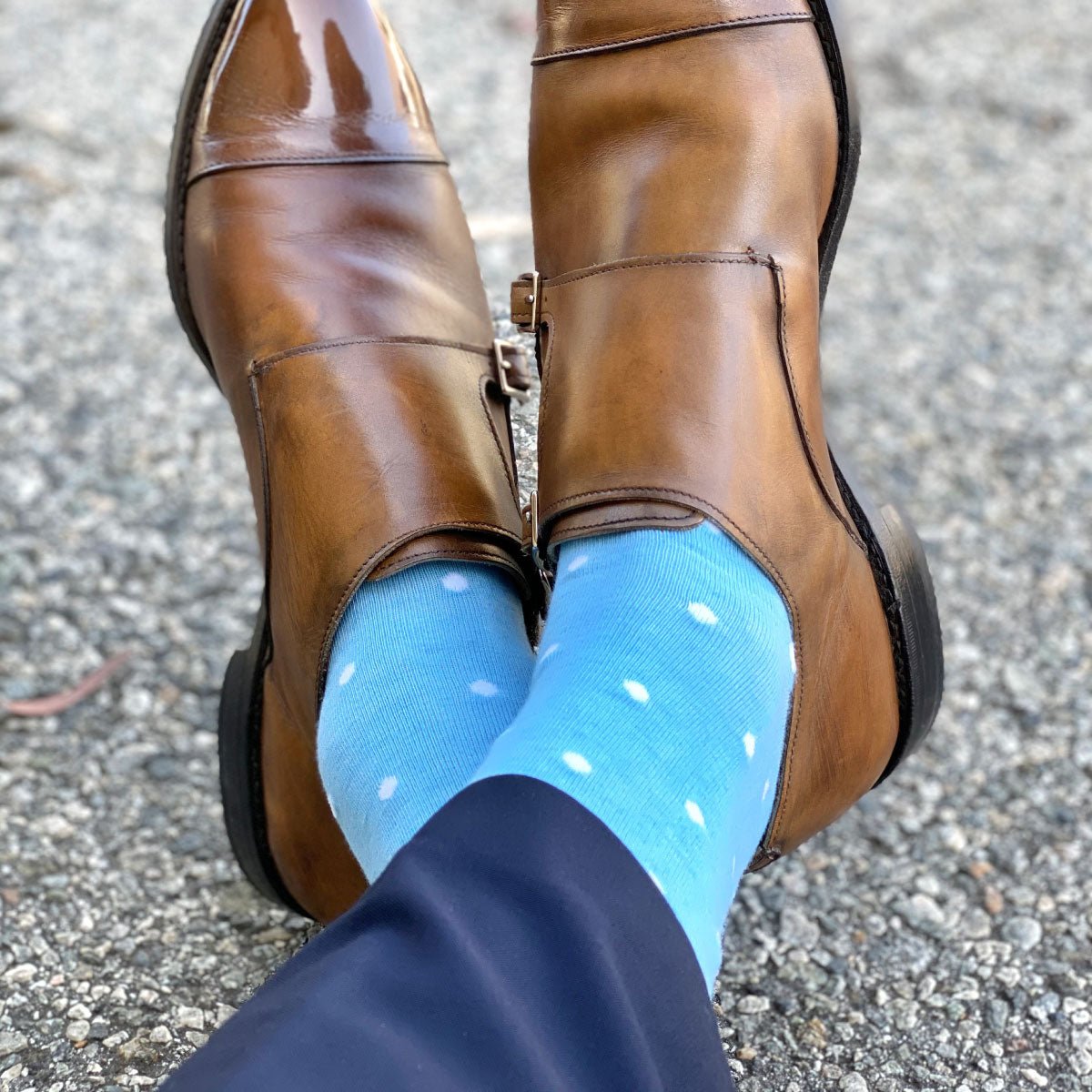 Man wearing navy slacks, light blue socks with white polka dots, and tan double monks trap shoes