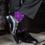 Man wearing purple dress socks with white hatches and dress shoes