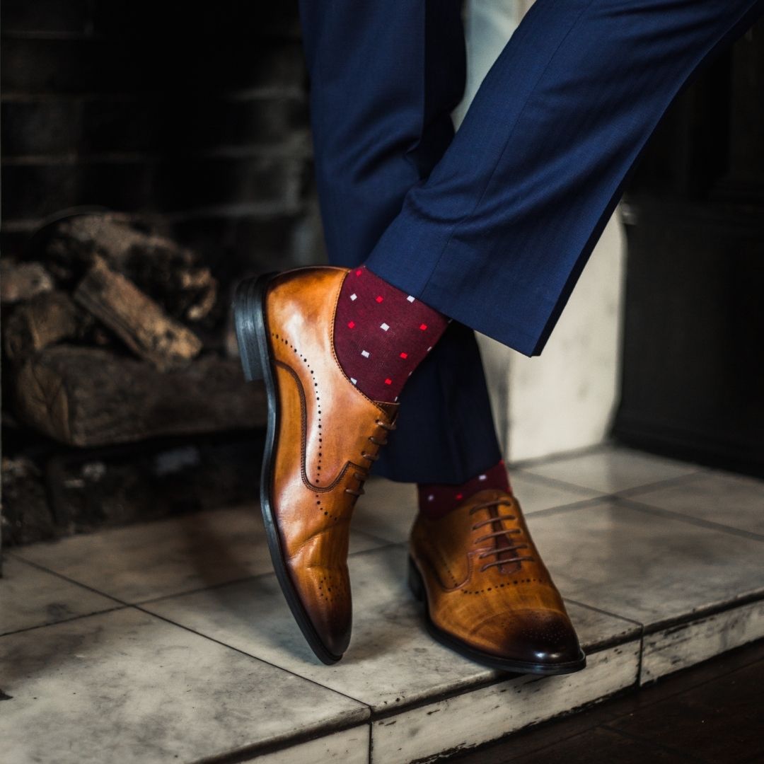 Man wearing cranberry socks with red and powder blue micro-squares