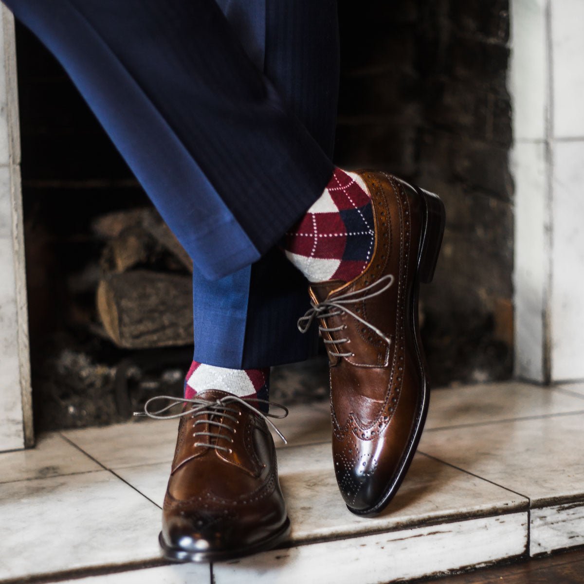 man wearing grey, red, and blue argyle socks