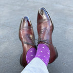 Man wearing purple dress socks with white hatches and brown dress shoes