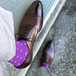 Man wearing purple dress socks with white hatches and brown dress shoes