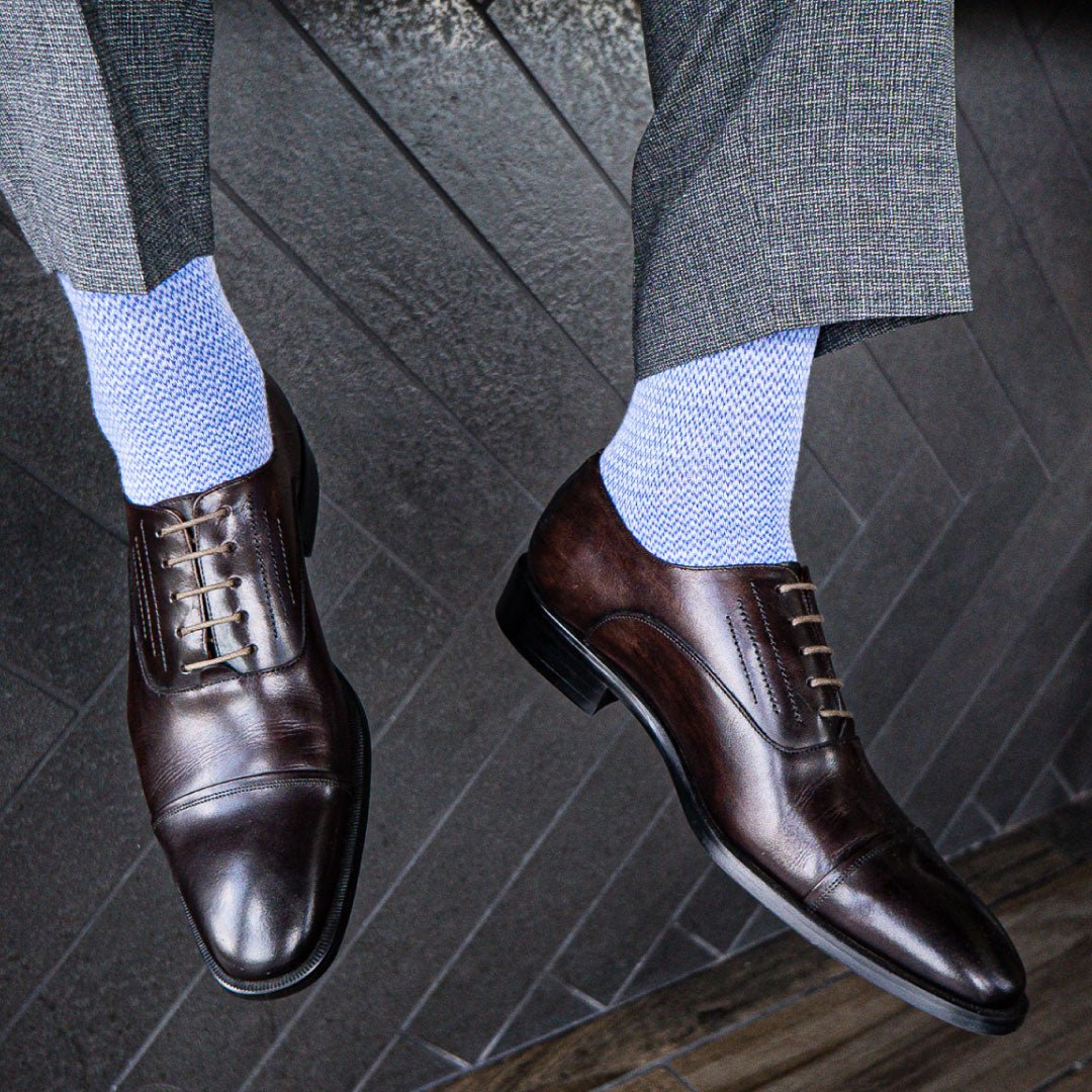 Man wearing Sky blue micro-chevron men's dress socks with grey trousers and brown shoes