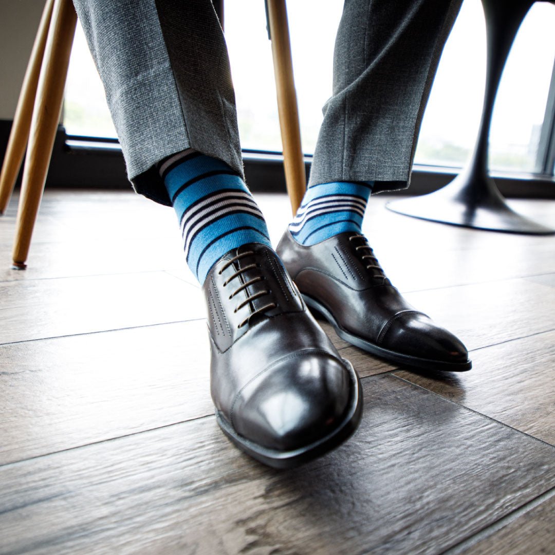 man wearing sky blue dress socks with navy and white stripes