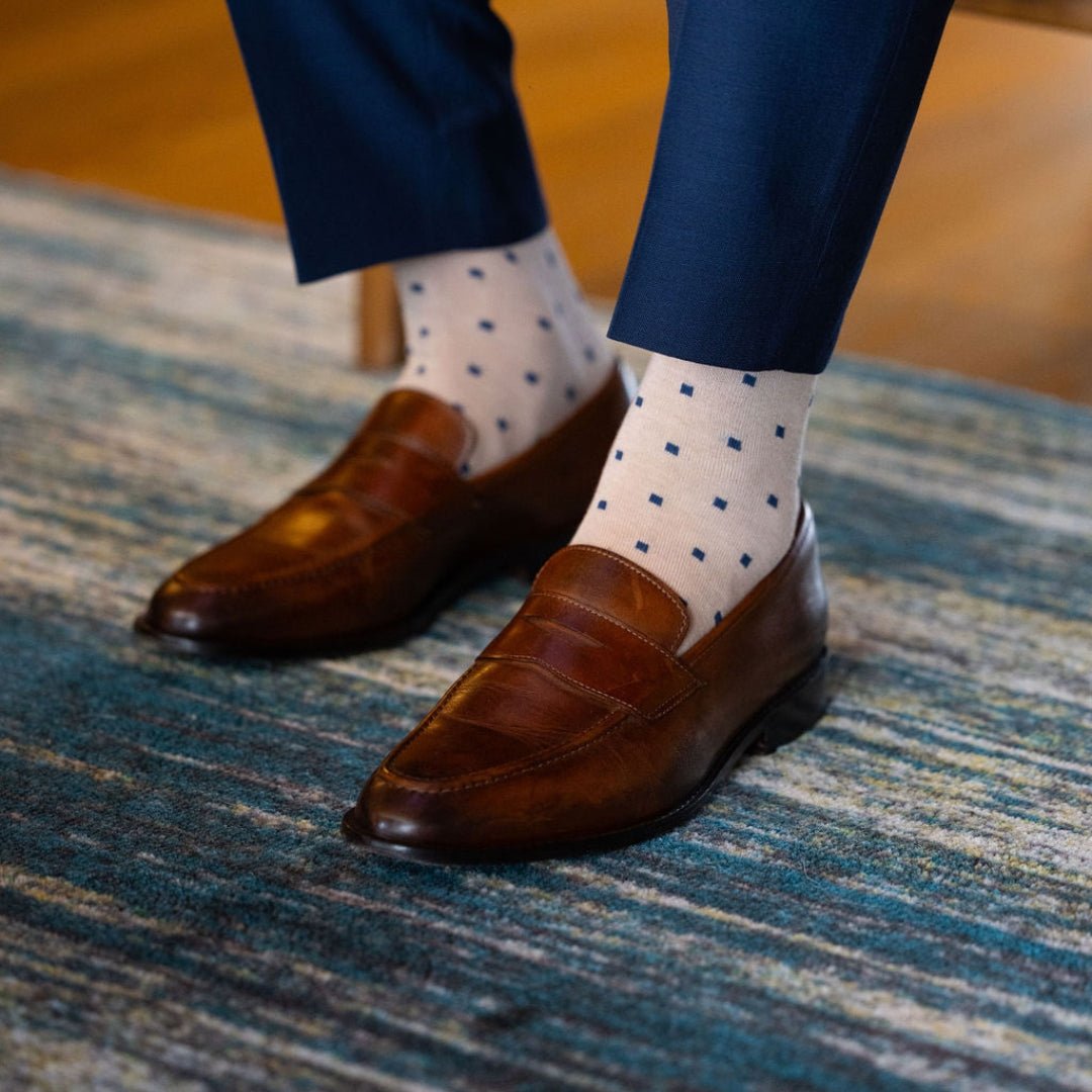 a tan men's dress sock with navy blue squares