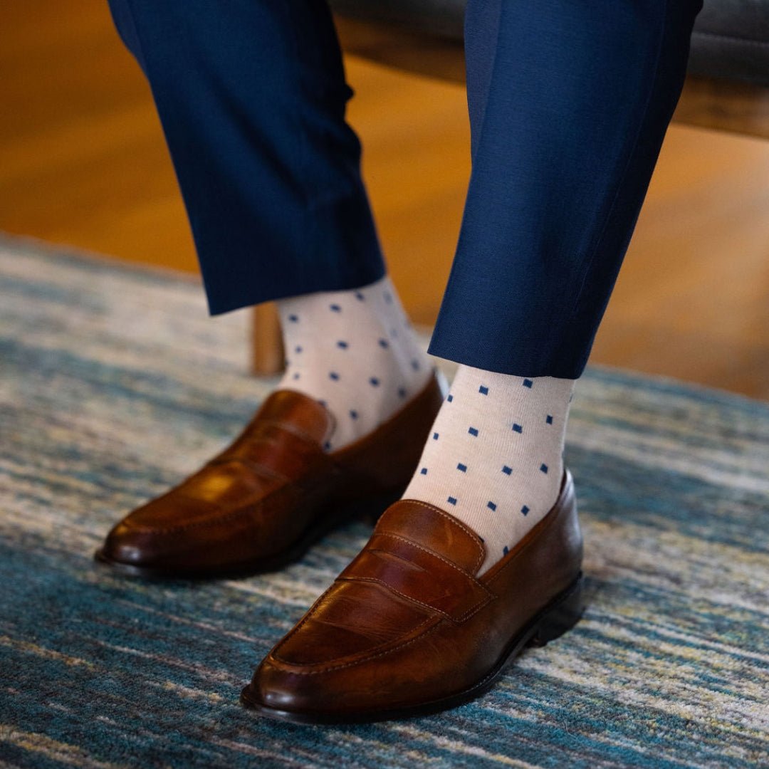 a tan men's dress sock with navy blue squares