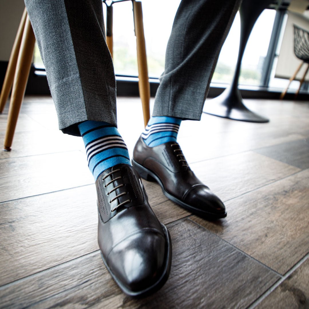 man wearing sky blue dress socks with navy and white stripes