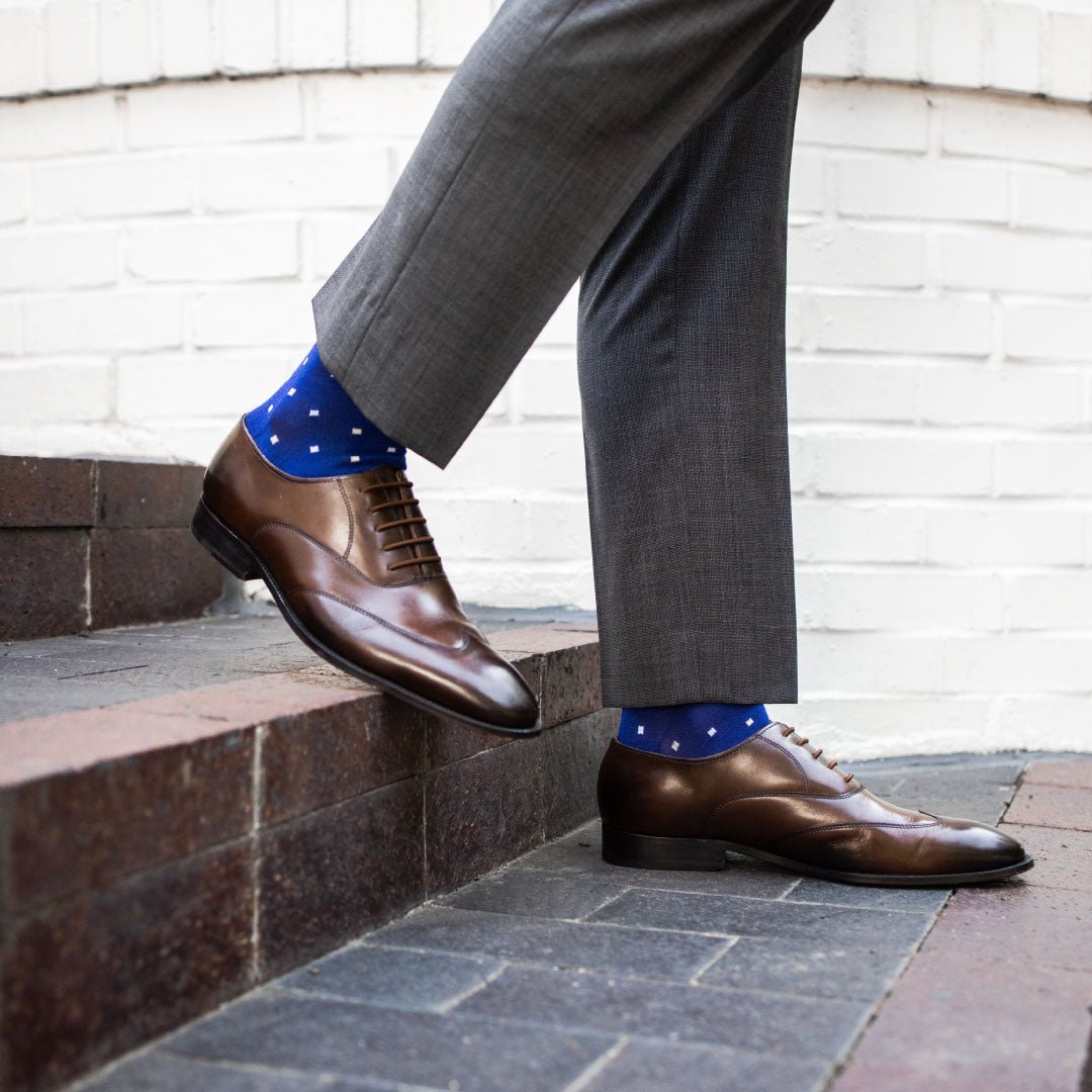 Man wearing sapphire blue, sand and white socks with brown shoes
