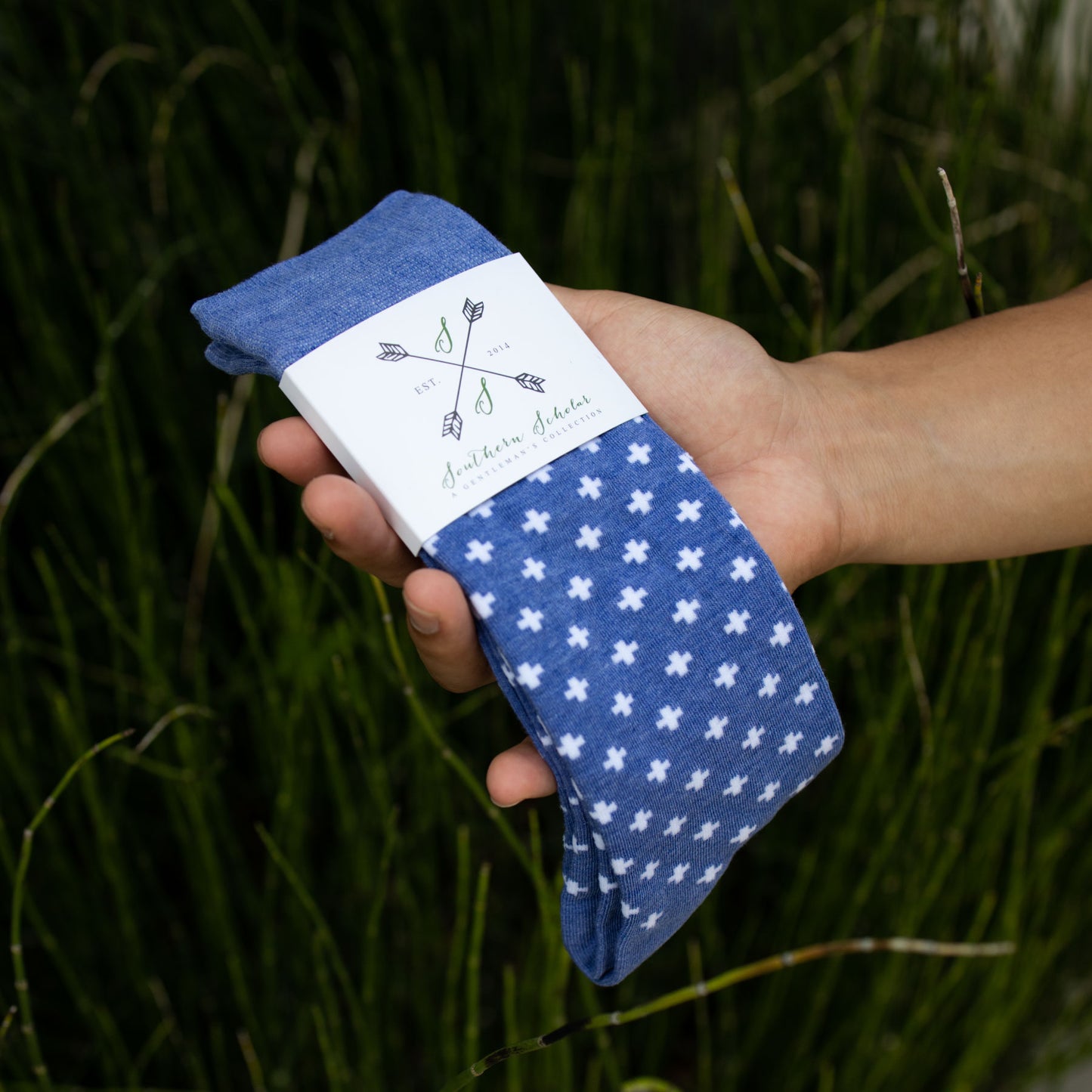 man holding blue mens dress socks with white pattern