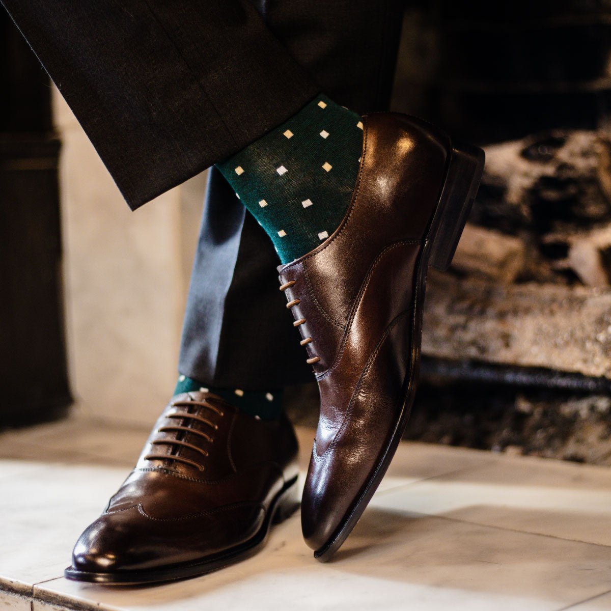 guy wearing charcoal grey slacks, green socks, with dark brown dress shoes