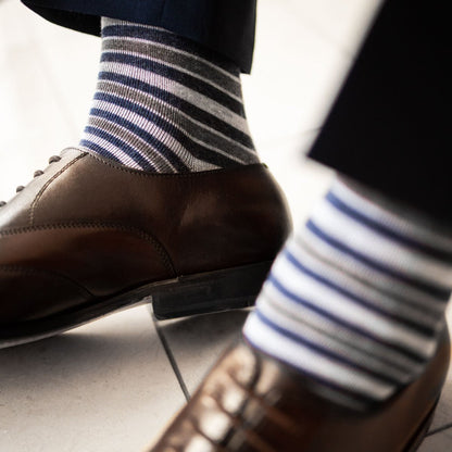 a man wearing grey, blue, and white striped men's dress socks with brown shoes