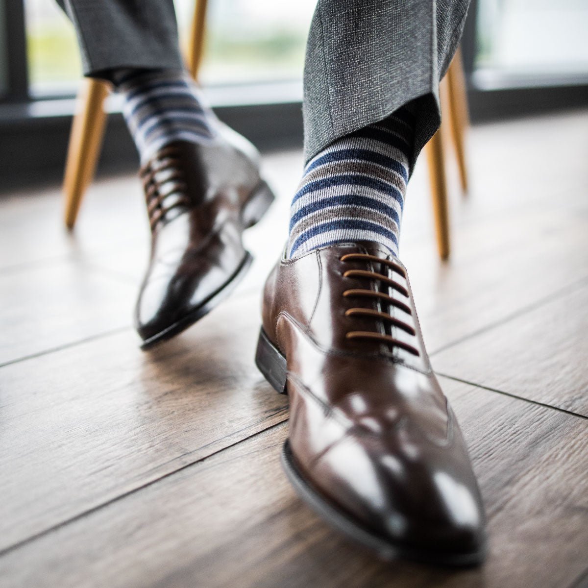 a man wearing grey, blue, and white striped men's dress sock