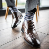 a man wearing grey, blue, and white striped men's dress sock