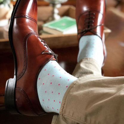 man wearing light blue socks with pink dots and brown shoes
