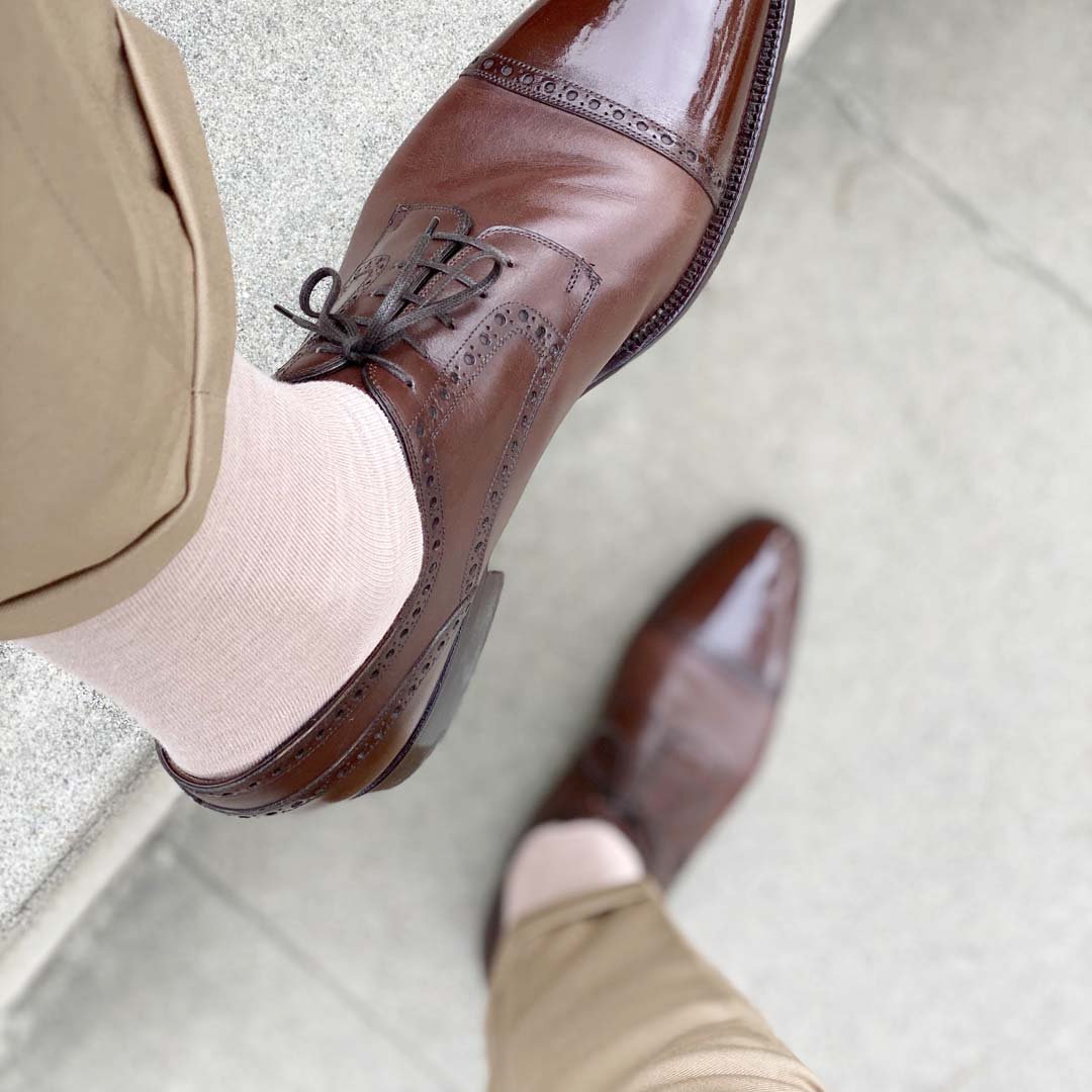 Man wearing slacks, oatmeal men's dress socks and brown shoes.