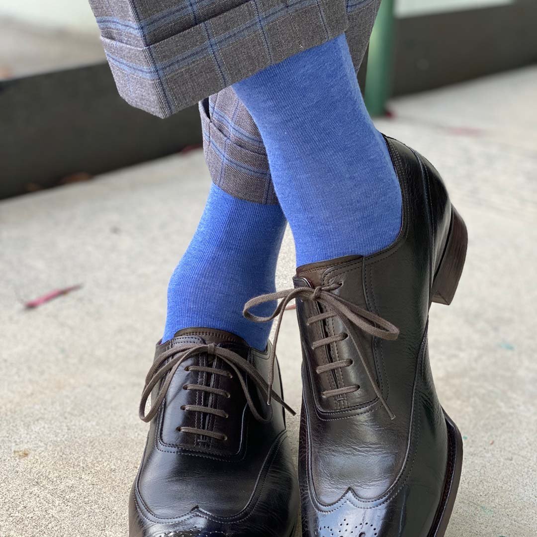 Man standing with feet crossed wearing steel blue men's dress socks.