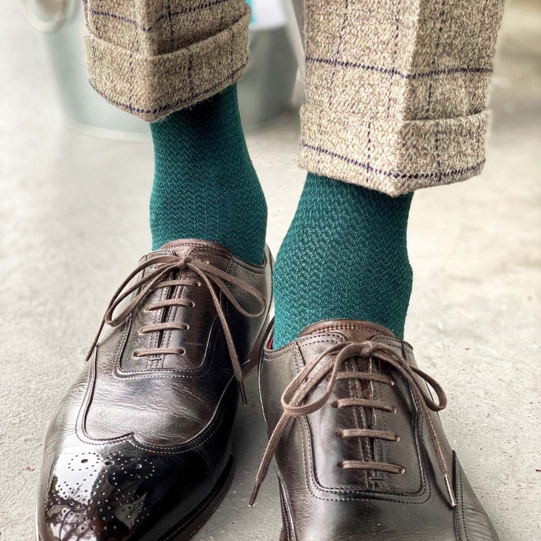 Man standing wearing hunter green socks and brown shoes