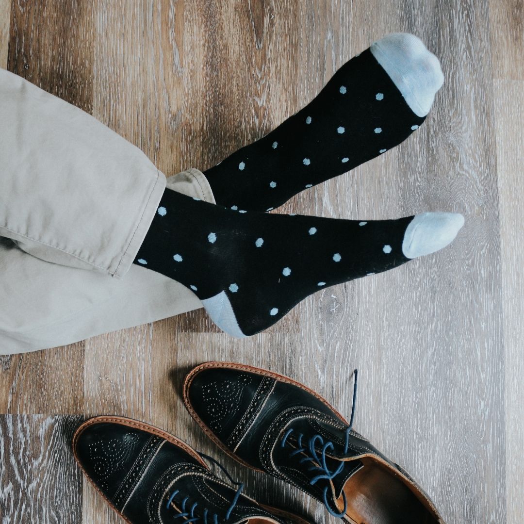 Man wearing black socks with blue polka dots