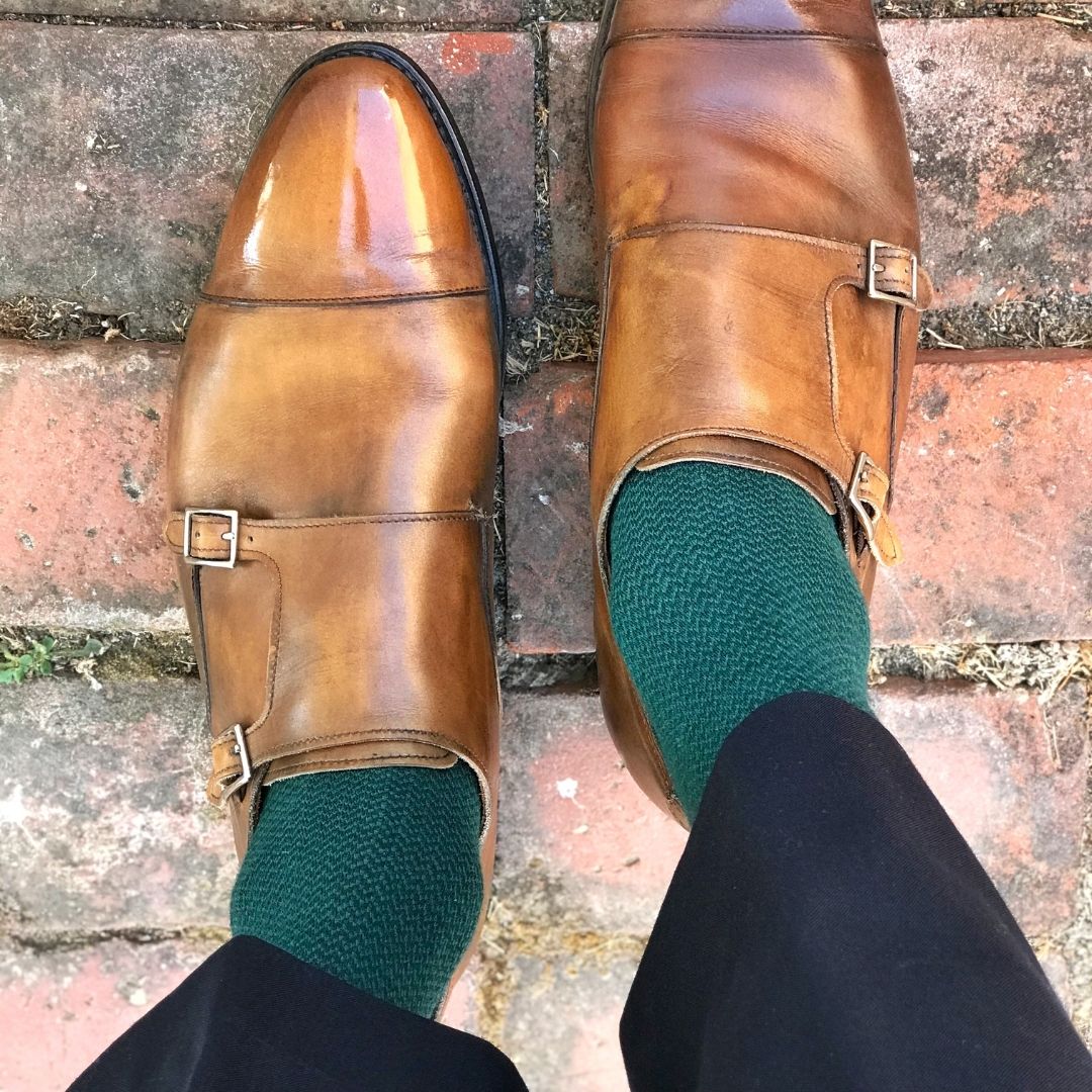 Man standing wearing hunter green socks and brown shoes