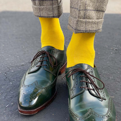 Man standing wearing canary yellow men's dress socks and shoes.