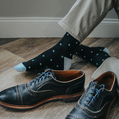 Man wearing black socks with blue polka dots 