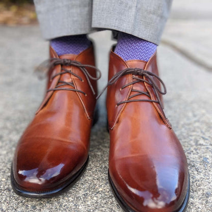Man standing wearing purple socks and brown shoes