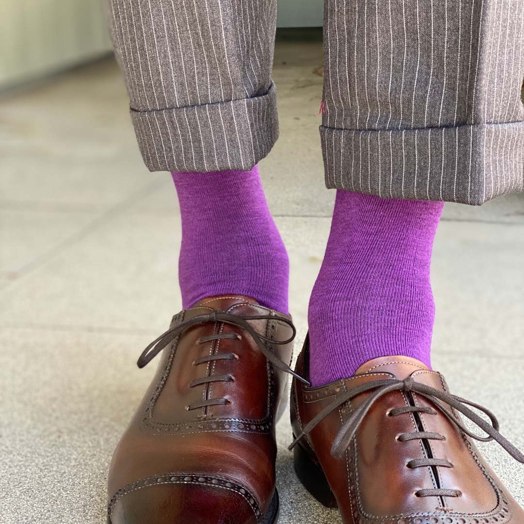 Man standing wearing plum purple men's dress socks and shoes.