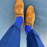 Man standing wearing sapphire blue, sand and white socks with brown shoes