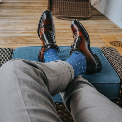 Man sitting with legs crossed wearing heathered blue and ocean blue micro-square socks
