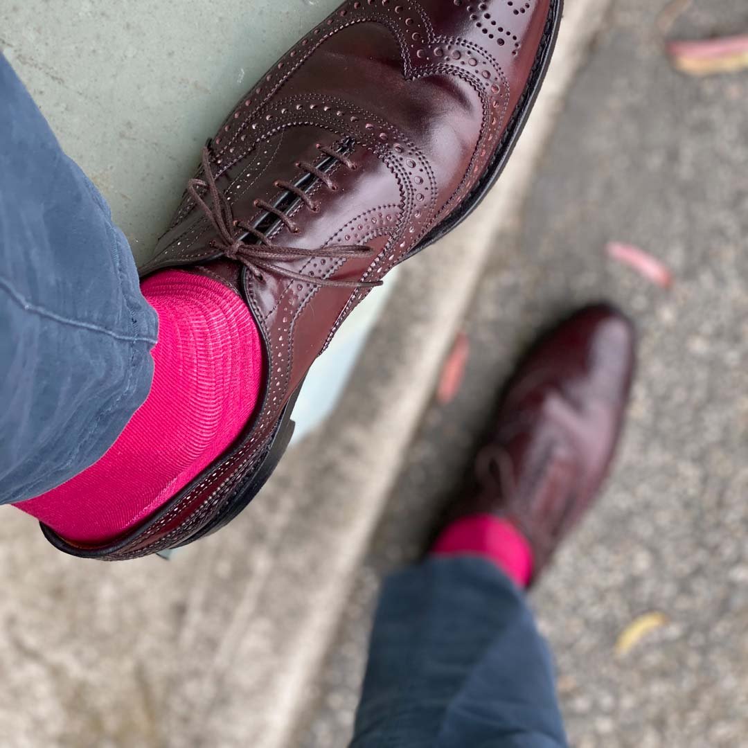 Man wearing ruby men's dress socks and brown shoes.
