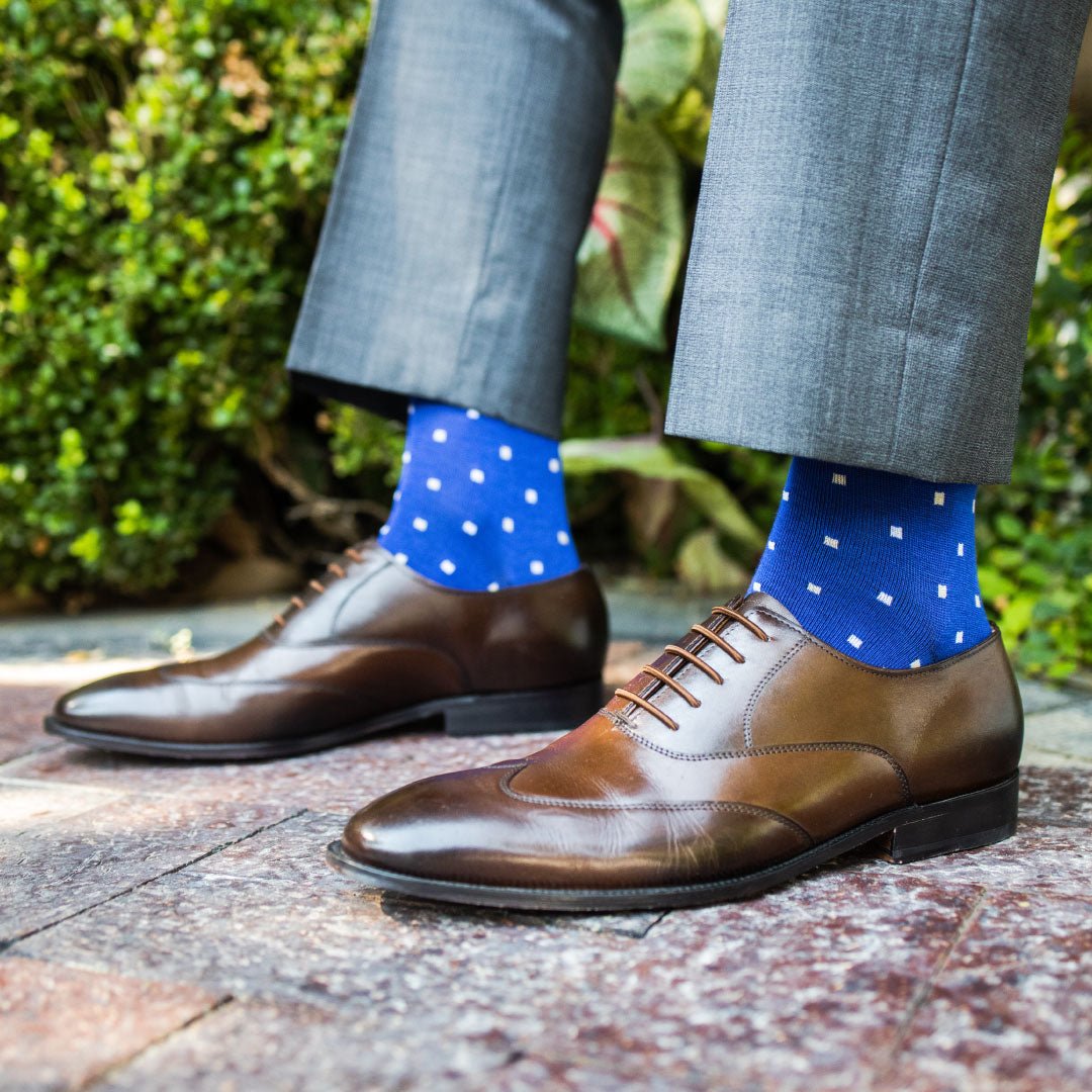 Man wearing sapphire blue, sand and white socks with brown shoes