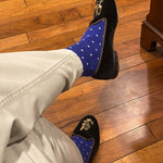 Man sitting with legs crossed wearing sapphire blue, sand and white micro-square socks 