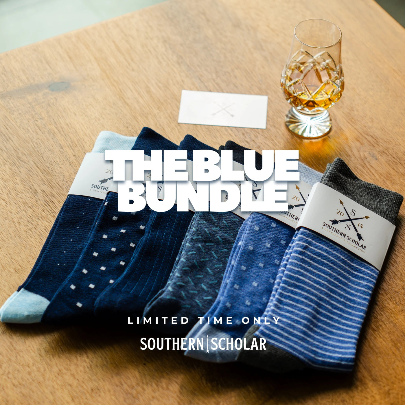 The Blue Bundle, six premium blue dress socks styled on a table with a whiskey glass